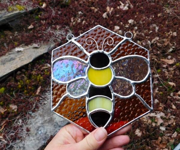 Hand holding stained glass bee on honeycomb lead free Mountain Woman Products